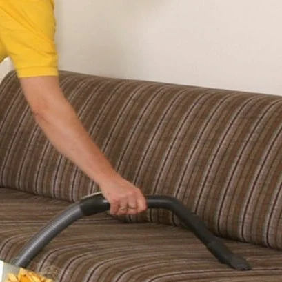 Frau beim Bügeln Eine Hand hält ein Dampfbügeleisen über einen pinken Stoff.